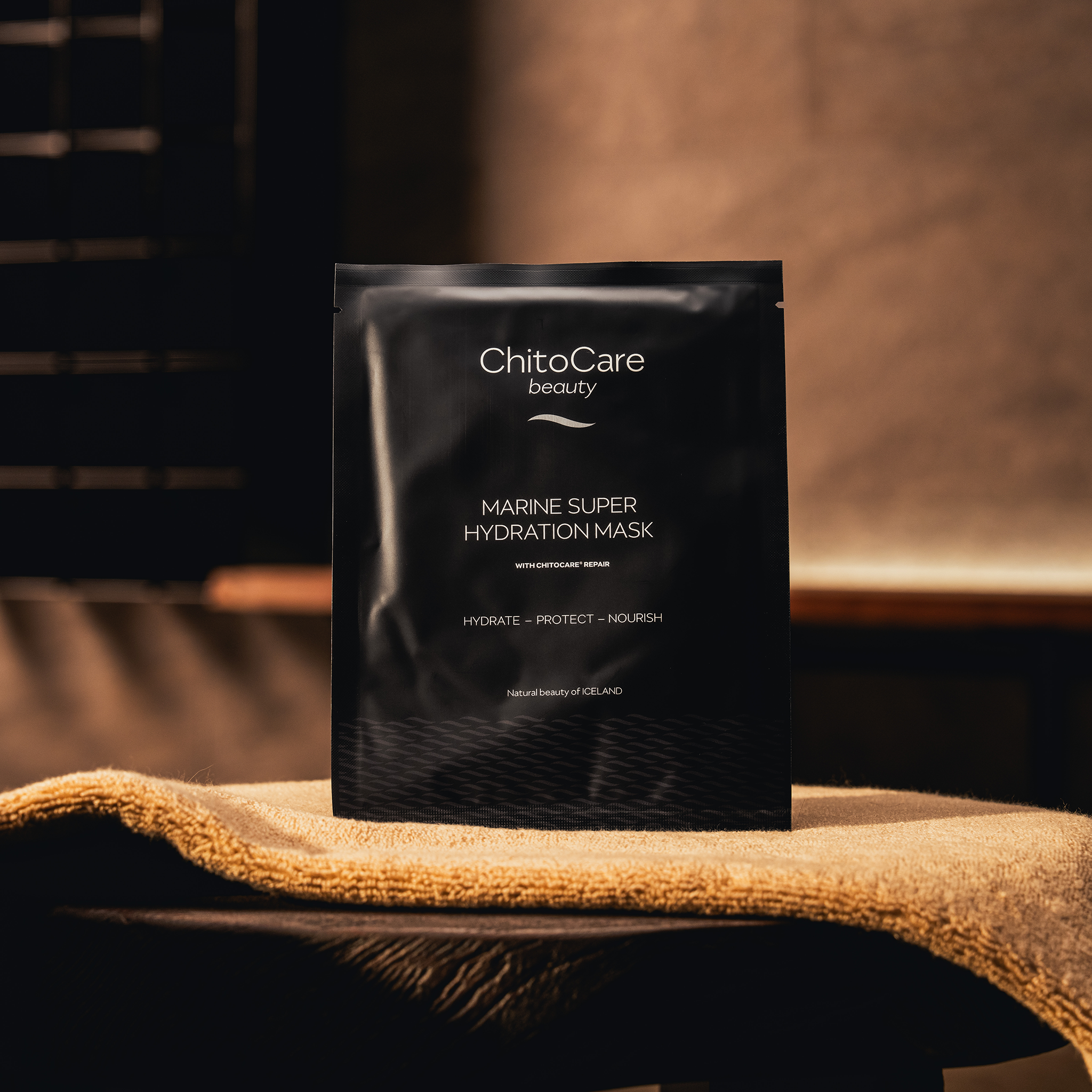 ChitoCare beauty Marine Super Hydration Mask packaging on a textured surface with a blurred background